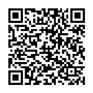 一个女孩吃力地将一大桶水倒进了院落的水缸之中二维码生成