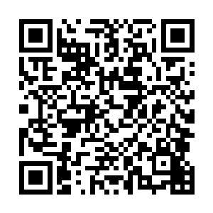 一个穿着睡袍站在这间房间里的男人向他询问房客的信息二维码生成