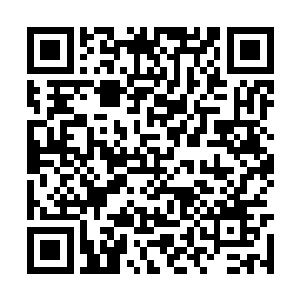 一个身材娇小玲珑的女子正在一间上房前来回度步二维码生成