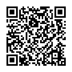 一个身穿白色李宁休闲装戴着顶棒球帽的男人低头走了出来二维码生成