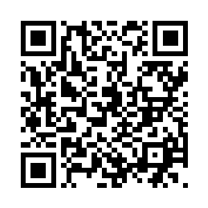 一人背对着他们正在炭火上烤着糯米团子二维码生成