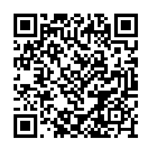 一位西装革履的青年男子站在黄埔无痕的书房里二维码生成