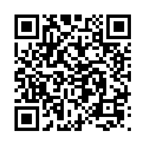 一名戴着眼镜的女子在一群白大褂的跟随下二维码生成