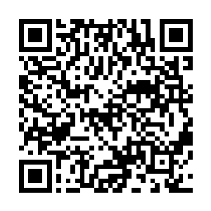 三个人站在一个四十多岁一头金发穿着皇族服饰的男子旁边二维码生成