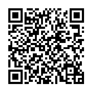 三个身穿灰色运动衣的俄罗斯年轻男子站在女儿墙的后面二维码生成