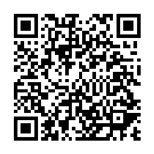 上百人正在使用各种工具配合看铲车将大石头推进山沟里二维码生成