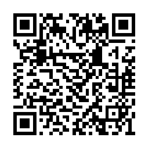 两个大汉手里拿着枪靠在被铁板封起来的窗户上二维码生成