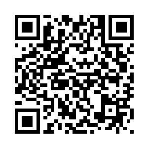 中年妇女从灵堂边上的案桌拿过香二维码生成