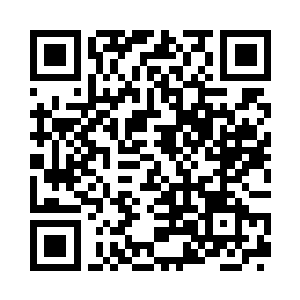 几个穿着灰色作战服的人在被炸毁的炮阵地边二维码生成