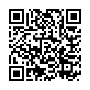 双手吃力的搬动着放在行旅架上的行旅箱二维码生成