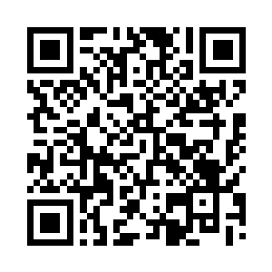 在一张椭圆形的大圆桌旁坐着七八人二维码生成