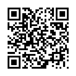 在他脚下摆着整整齐齐三口半米高大箱子二维码生成