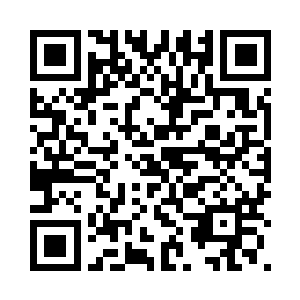 在宾馆的房间里看着电视上的新闻二维码生成