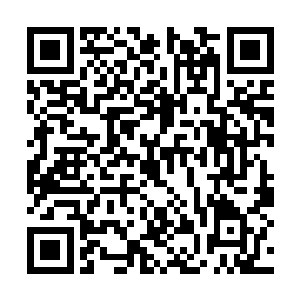 头上带着魔鬼面具的男子站在一座小岛的海崖之上二维码生成