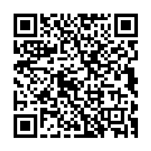 她穿着一身花团锦绣上面镶满祥云和花朵图案的少数民族服装二维码生成