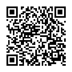 年轻的女孩儿一边看着手中的杂志一边问着身旁的好友二维码生成