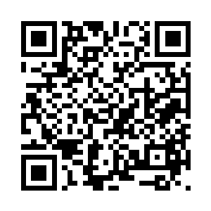 戴着黑框眼镜的总裁助理吴月正站在通道里二维码生成