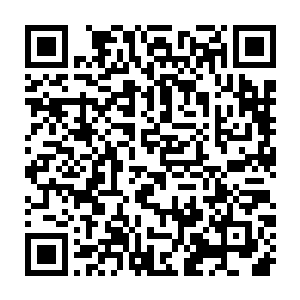 有华夏军战士在倾倒的旗帜下将那名已然死去的女真将领的头颅砍了下来二维码生成