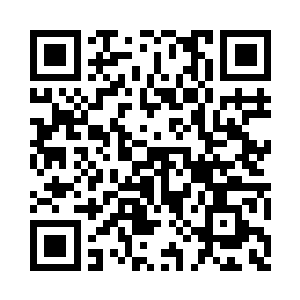 皱紧了眉头指窗边脚架上的数码摄像机二维码生成