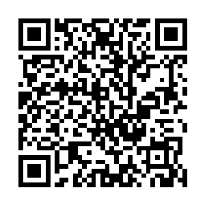 黄衣女子正躲在一块大石头身后处理着自己手臂上的伤势二维码生成